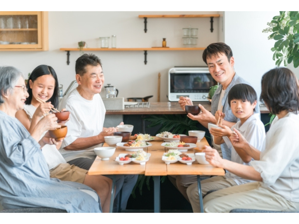 家族で食卓を囲みいっしょに食事をする様子